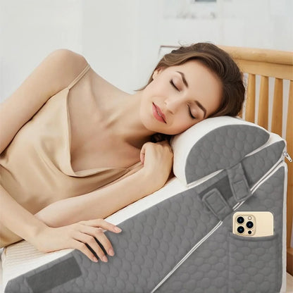 Woman lying on a bed with a gray wedge-shaped pillow and a phone in a pocket.