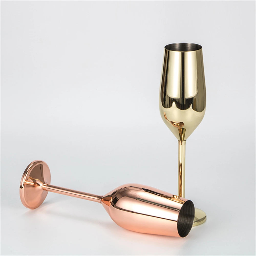 Gold and rose gold champagne flutes on a light gray background