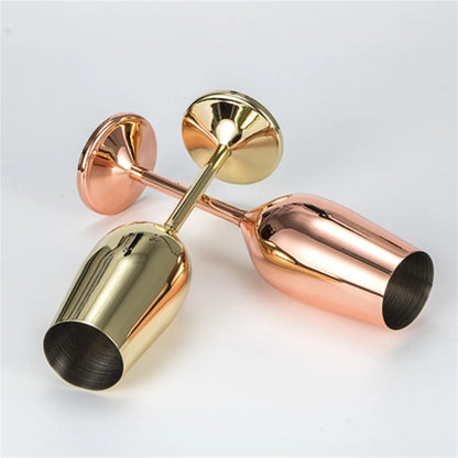 Gold and rose gold drink stirrers on a light gray background