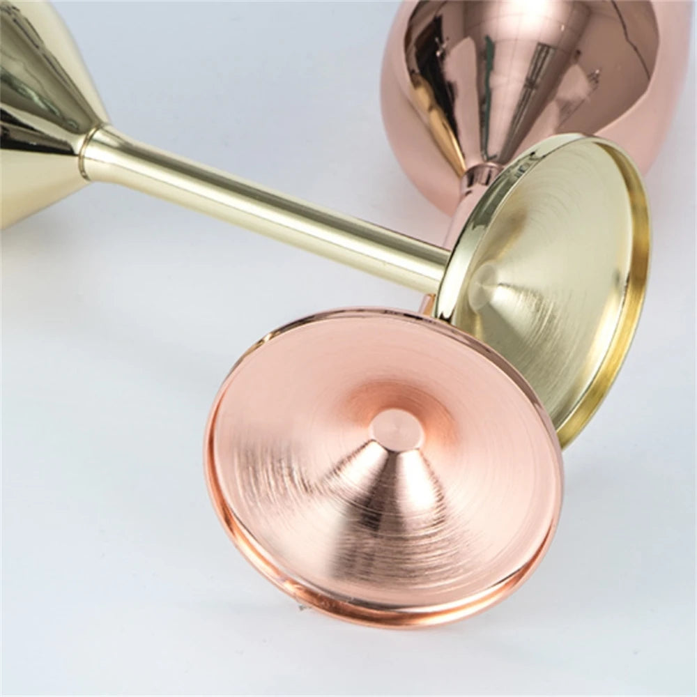 Close-up of rose gold and gold measuring cups on a light gray background