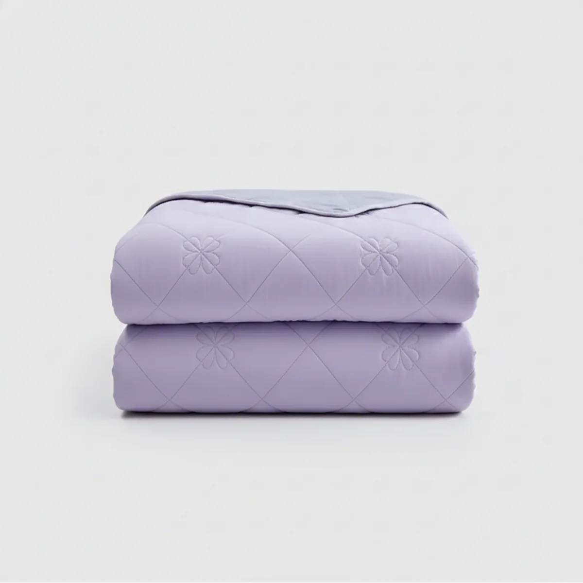 Folded purple quilt on a light gray background
