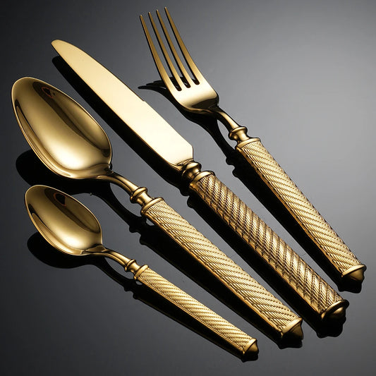 Set of gold cutlery with textured handles on a dark background