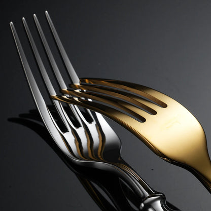 Two forks, one gold and one silver, on a dark background