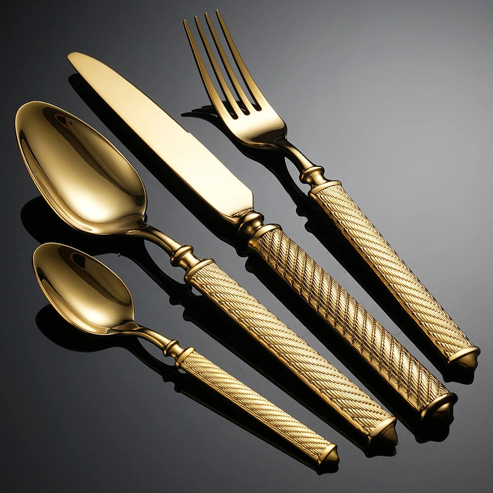 Set of gold cutlery with textured handles on a dark background