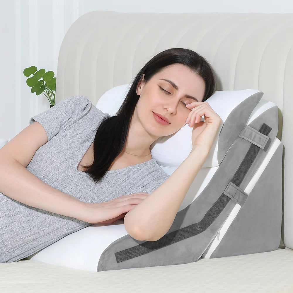 Woman using a gray wedge pillow on a bed