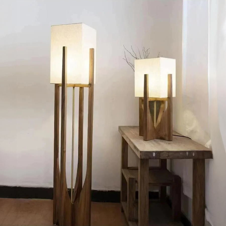 Two wooden floor lamps with white lampshades in a room setting.