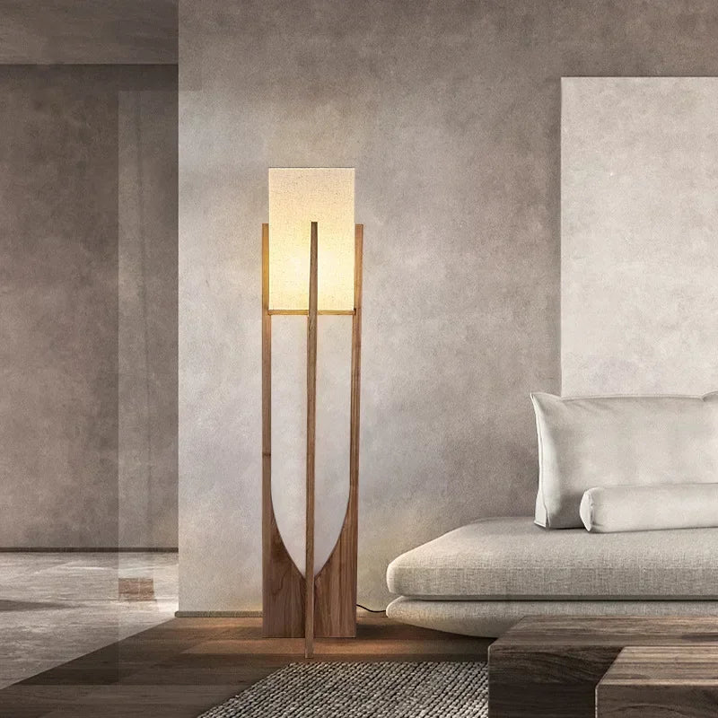 Modern floor lamp in a living room setting with a sofa and decorative pillows.