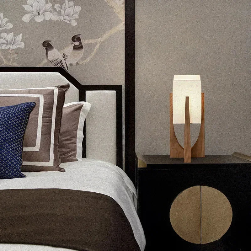 Modern bedroom with a bed, nightstand, and decorative lamp.