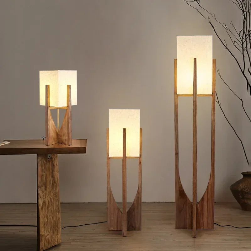 Three wooden lamps of different heights on a neutral background