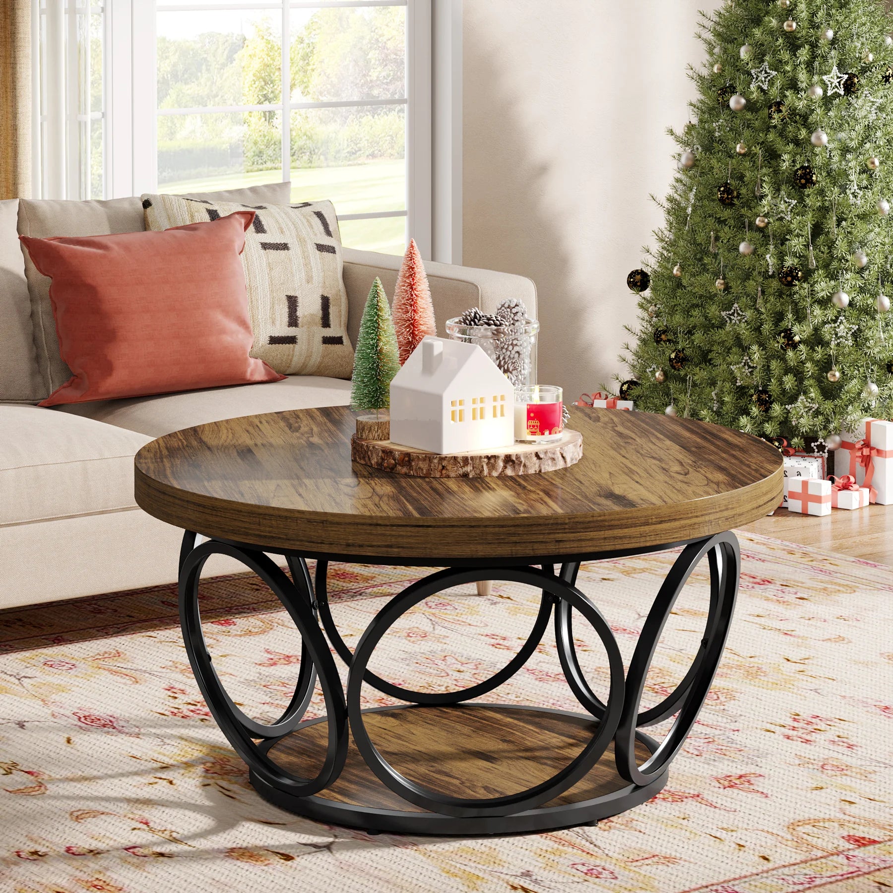 Wooden coffee table with decorative items in a living room with a Christmas tree.