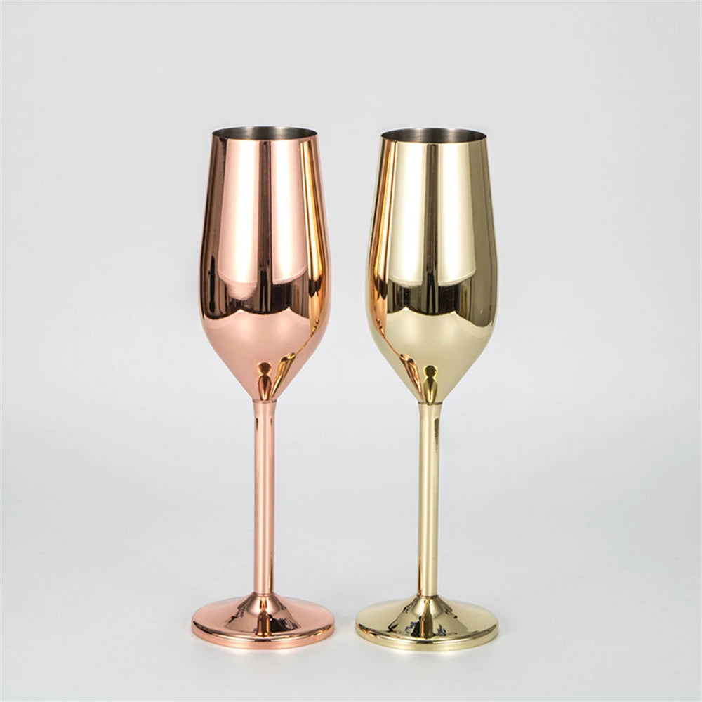 Two metallic champagne flutes, one rose gold and one gold, on a light gray background.