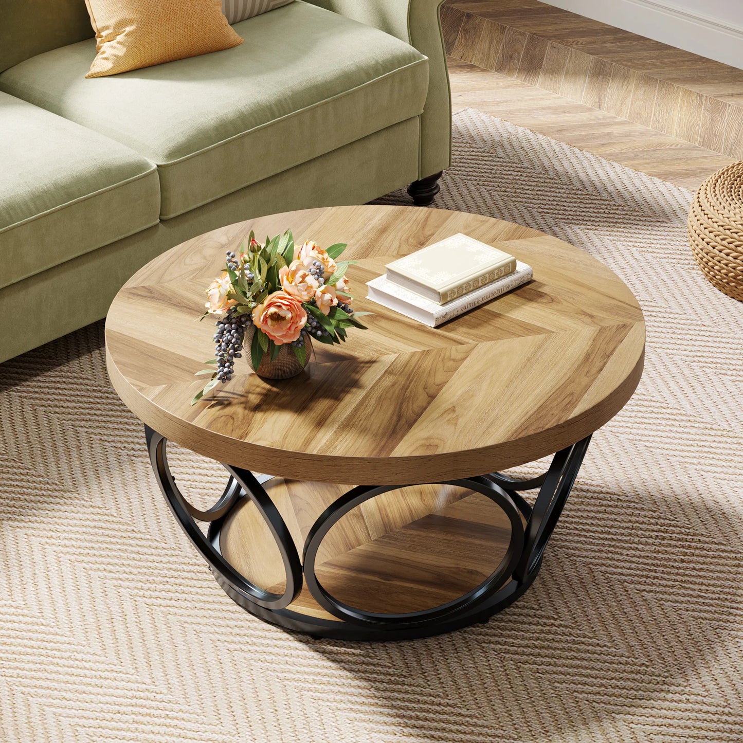 Round wooden coffee table with a vase of flowers and books in a living room setting.