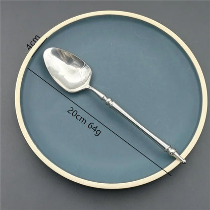 Silver spoon on a round blue and beige plate with measurements.